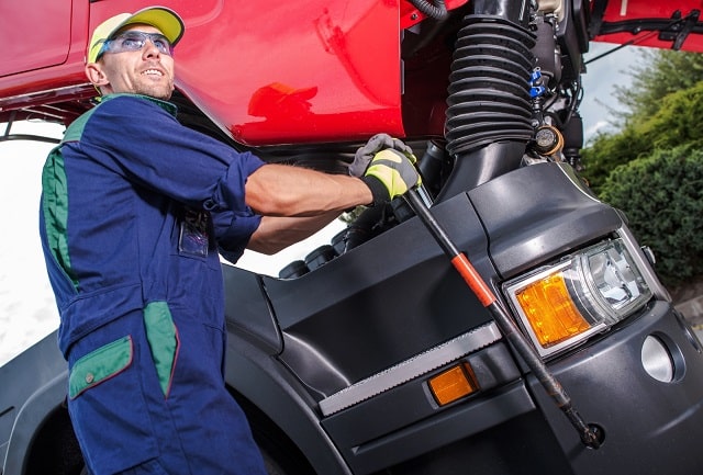 Mechanic performing maintenance on a semi truck