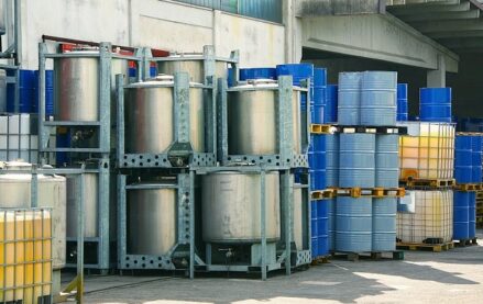 Chemical storage totes, containers, and drums outside a warehouse