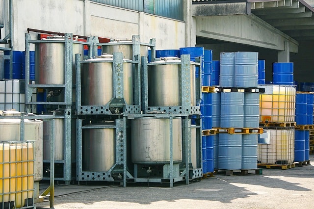 Chemical storage totes, containers, and drums outside a warehouse