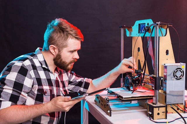 Design engineer using 3D printer to evaluate prototype