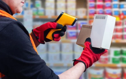 Worker scanning barcode labels with a handheld barcode scanner for product identification