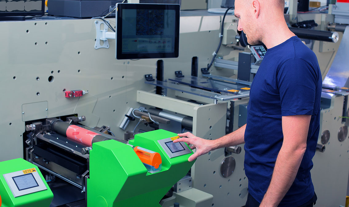 Industrial worker reviewing data on a metal label to operate equipment